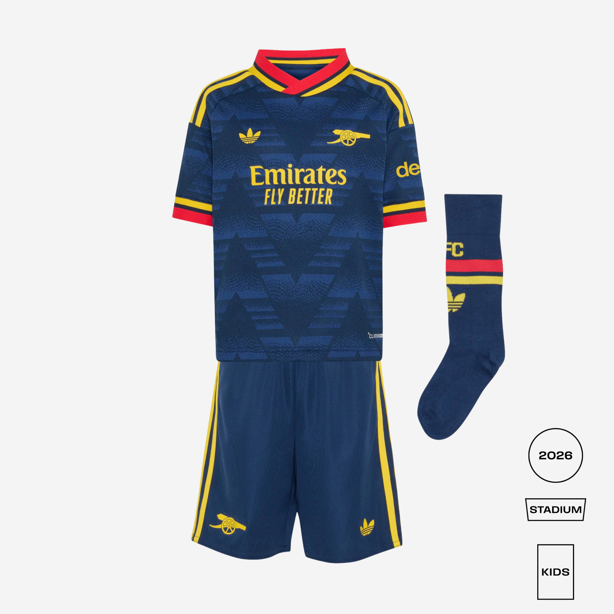 A kids' Arsenal football kit set featuring a navy blue patterned jersey with red and yellow trim, matching navy shorts with yellow stripes, and a navy sock with red and yellow accents. The kit is displayed on a light gray background with product details and a '2026 STADIUM KIDS' label.