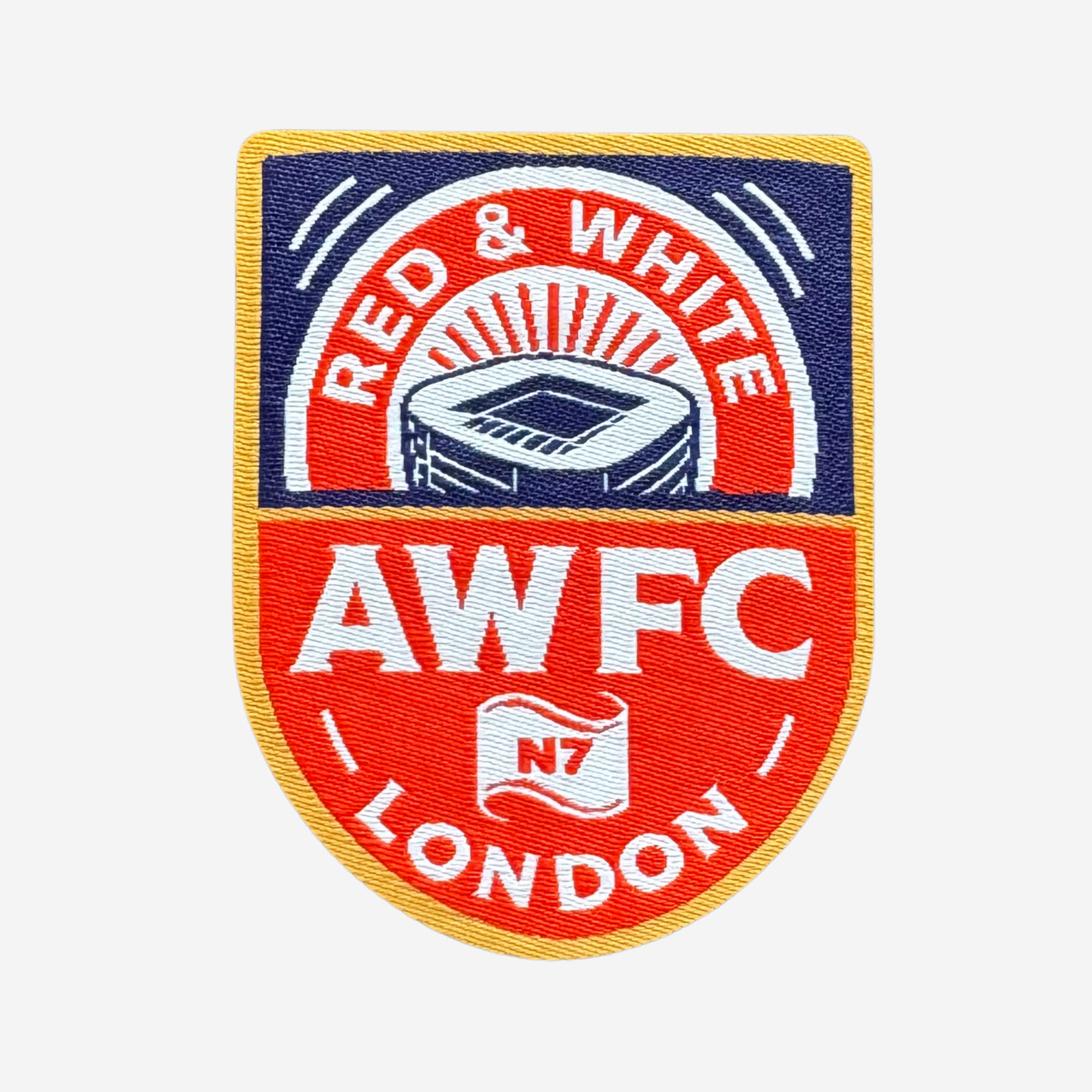 A shield-shaped embroidered patch featuring the text 'RED & WHITE' at the top, a stylized stadium illustration in the center, and 'AWFC LONDON' with 'N7' below, shown on a plain light background.