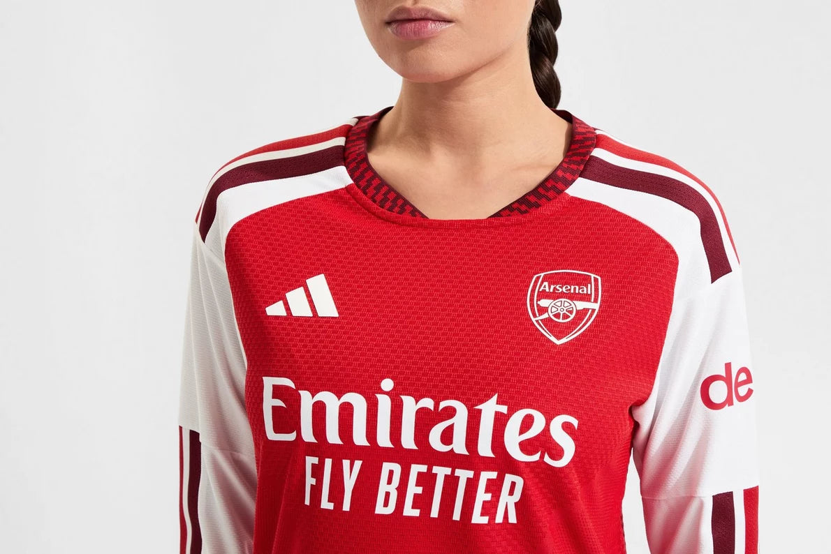 Person wearing a red and white Arsenal football jersey with Adidas logo.