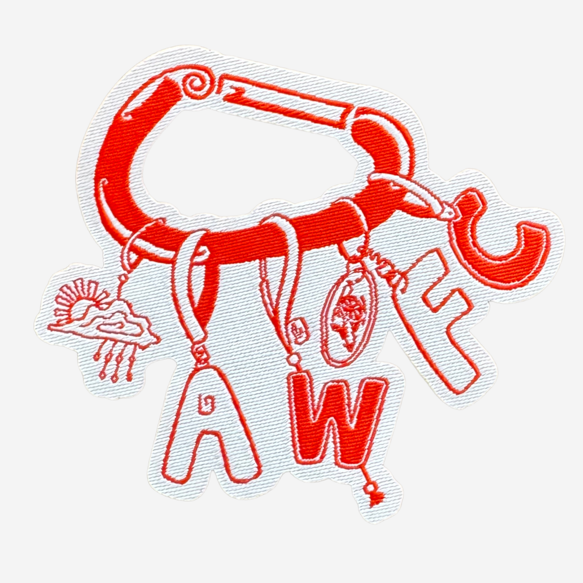 A red embroidered patch or applique featuring a carabiner shape with dangling letter and symbol charms on a light gray background.