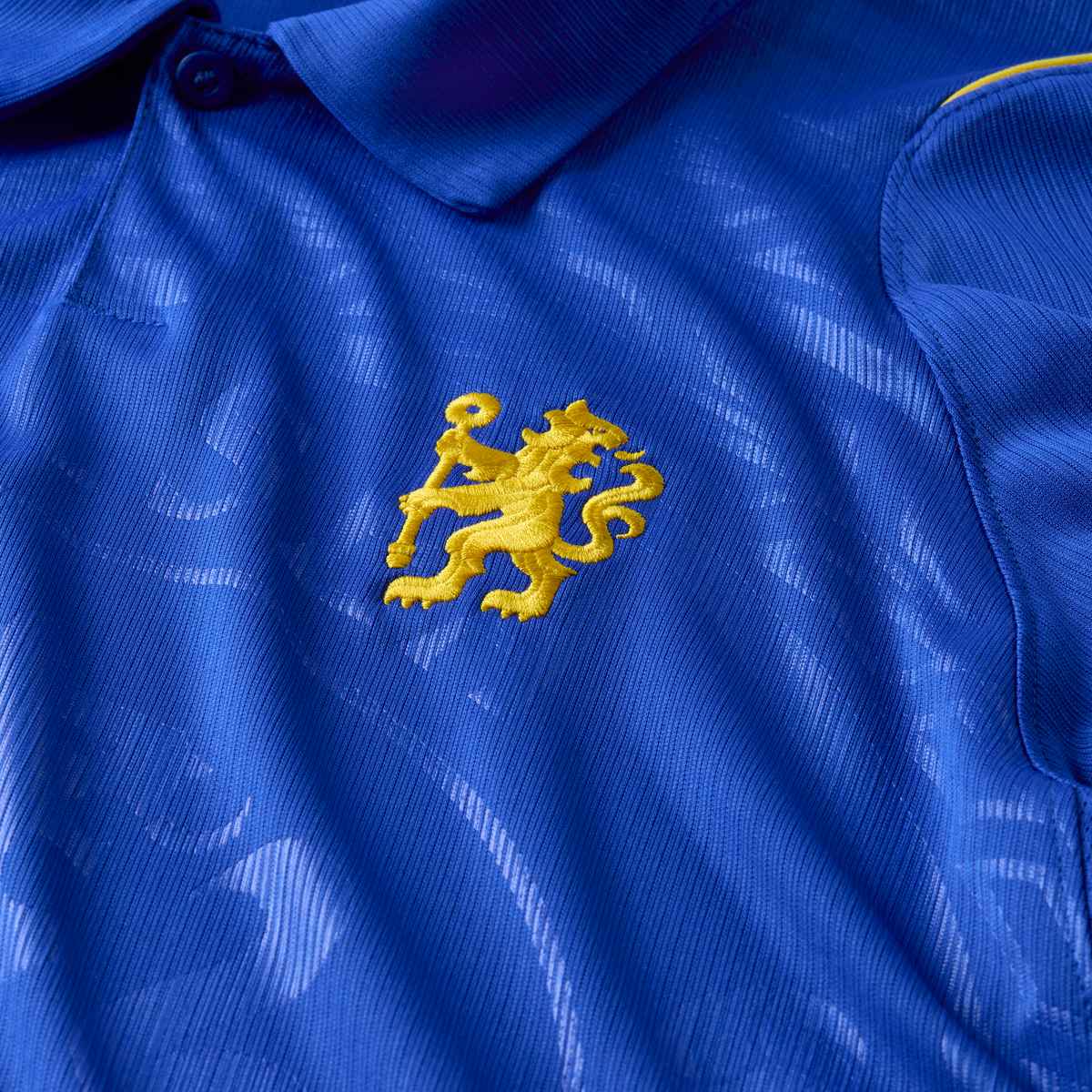 Close-up of a blue fabric with a yellow embroidered emblem