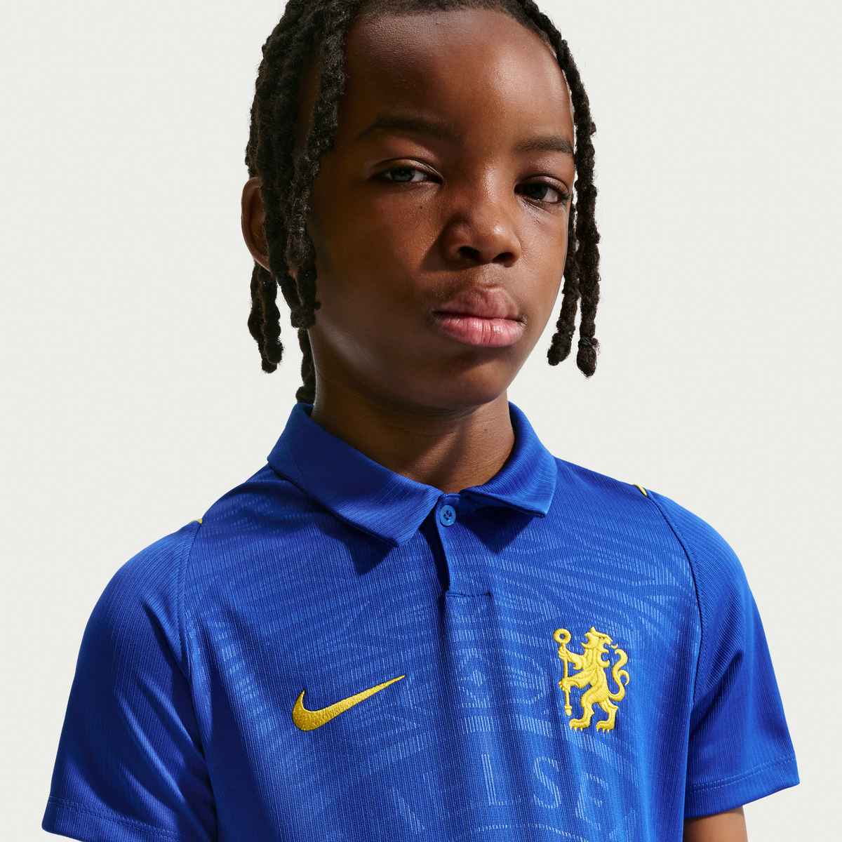 Child wearing a blue sports jersey with a logo on a plain background