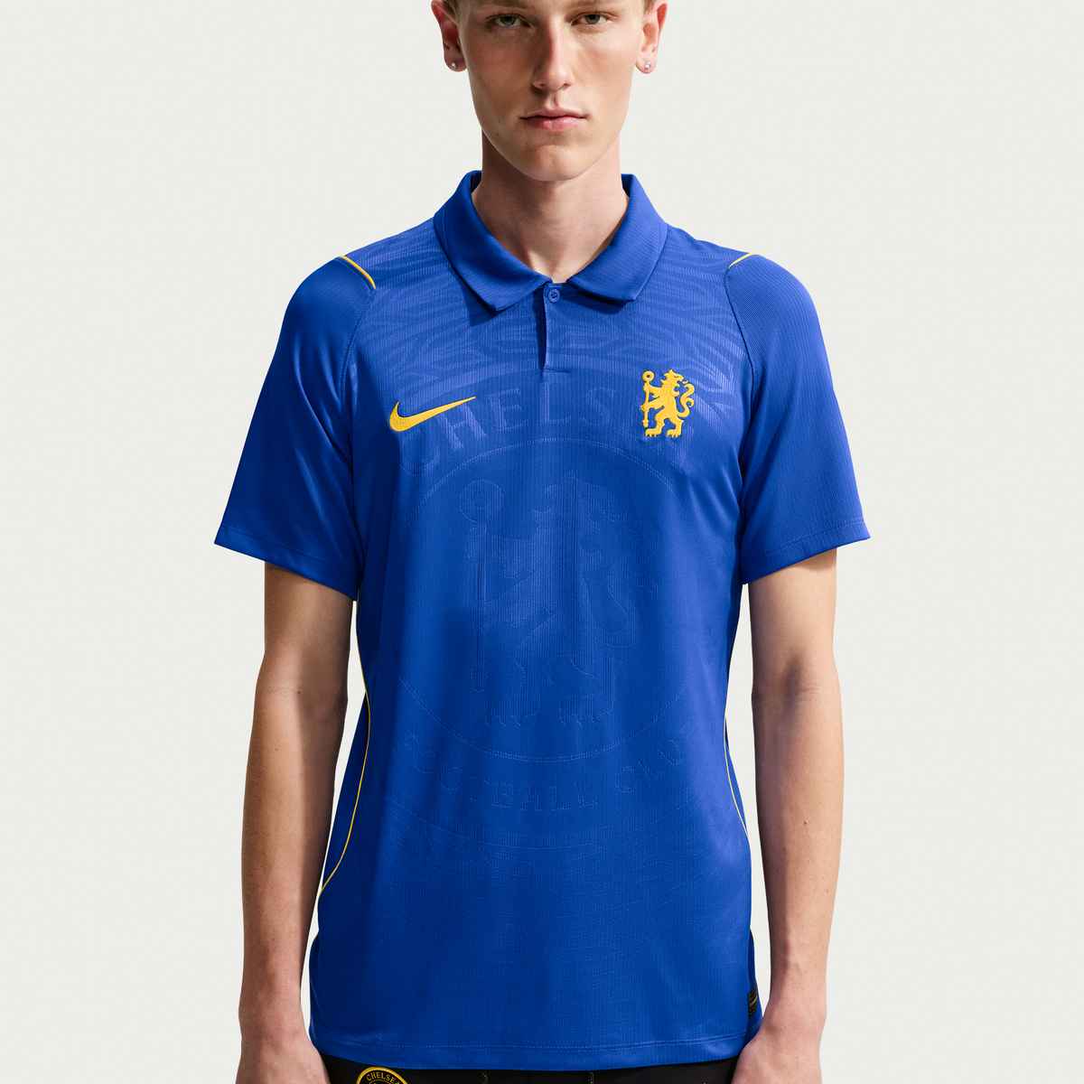 Person wearing a blue sports jersey with a logo on a white background